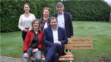 Passend zum Thema der Gesprächsrunde über soziale Teilhabe und Stärkung der Zivilgesellschaft sitzen SPD-Co-Chef Lars Klingbeil und SPD-Bundestagskandidatin Frauke Langen in Bremervörde auf einer symbolträchtigen Bank, auf der ein Platz aus gutem Grund fehlt. Im Hintergrund: Lars Lust (von rechts) und Doris Brandt vom SPD-Ortsverein Bremervörde sowie Ina Helweg, Co-Vorsitzende des SPD-Unterbezirks Rotenburg.