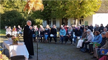 Ein Pastor steht am Mikrofon und hält eine Rede. 