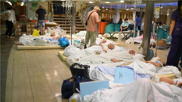 Griechenland kämpft gegen zahlreiche Brände Patienten liegen auf dem Boden einer Fähre, nachdem die Gesundheitsbehörden ein Krankenhaus in Alexandroupolis teilweise evakuiert haben.