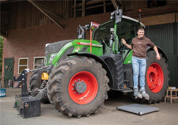 Drohnen im Einsatz: Schüler entdecken moderne Landwirtschaft Ein junger Mann mit braunem Sweatshirt und blauer Jeans springt von einem Traktor.