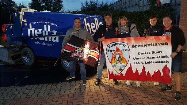 Menschen mit Banner vor Eismaschine.