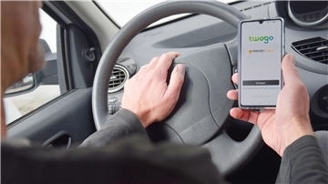 Mann guckt im Auto sitzend auf ein Handy