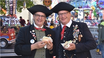 Peter Igelmann und Jürgen Voege in Artländer Festtagstracht. Gut gelaunt ziehen die beiden Teilnehmer des Landestrachtenfestes fröhlich grüßend durch das bunte Jahrmarkttreiben in der Fußgängerzone.