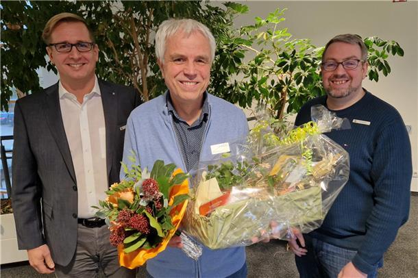 Seine Leidenschaft gilt Bits, Bytes und Oldtimern: IT-Experte begeht Jubiläum Gruppenfoto Drei Männer der in der Mitte hat einen Blumenstrauß