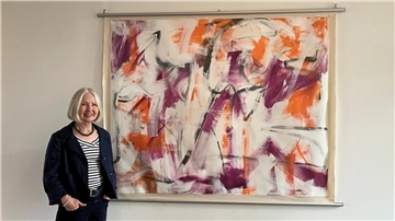 Petra M. Tränkner vor dem Bild „Innenwelt“, von dem sie sagt, dass es ganz untypisch für sie sei. Normalerweise beginnt sie so zu malen, die erste Schicht ihrer Arbeiten sind abstrakte Hintergründe. Und die stellt sie normalerweise nicht aus.