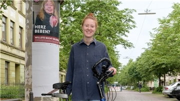 Pheline Hanke radelt durch die Stadt, hält auf Litfaßsäulen und an Haltestellen Ausschau nach den riesigen Plakaten, die sie für die Frauen-Herz-Kampagne gestaltet hat.