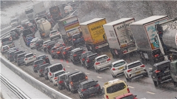 PKW, Busse und LKW stehen auf der Autobahn A8 am Irschenberg im Stau.