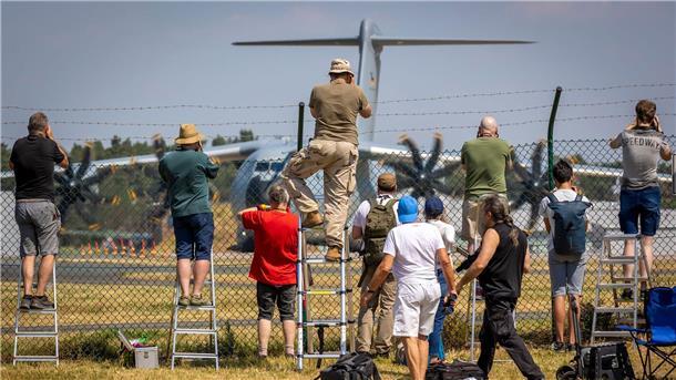 „Air Defender“ zieht Zaungäste an Planespotter stehen an einem Zaun vor dem Fliegerhorst Wunstorf und fotografieren einen Airbus A400M der Luftwaffe.