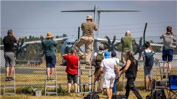 Planespotter stehen an einem Zaun vor dem Fliegerhorst Wunstorf und fotografieren einen Airbus A400M der Luftwaffe.