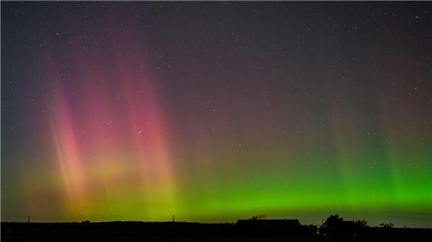 Polarlichter über dem Norden und Osten Polarlicht und Komet leuchten am Nachthimmel.