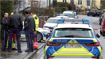 Polizei und Notarzt stehen vor dem Haus in Regensburg, in dem sich die Gewalttaten ereigneten.