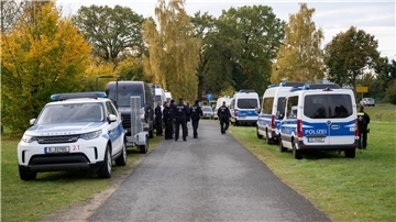 Polizeiautos stehen auf einer Wiese in Tauche. 