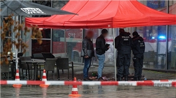 Polizeibeamte untersuchen unter einem Zeltdach den Tatort in Gummersbach.