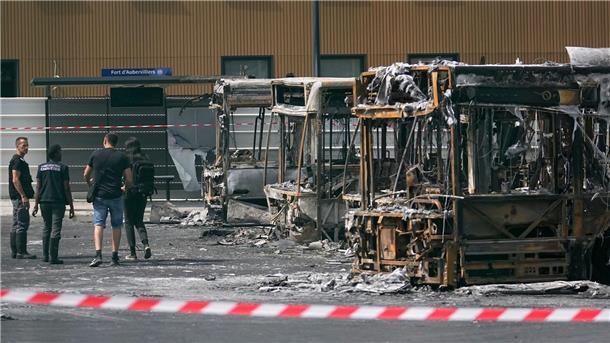 Polizeiermittler vor ausgebrannten Bussen in Aubervilliers.