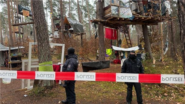 Polizei löst Tesla-Protestcamp komplett auf Polizeikräfte sichern das Waldgebiet hinter einer Absperrung. Umweltaktivisten, die gegen Tesla protestieren, müssen ihr Camp räumen.