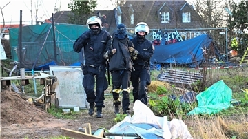 Polizisten führen einen Klimaaktivisten in Lützerath vom Gelände.