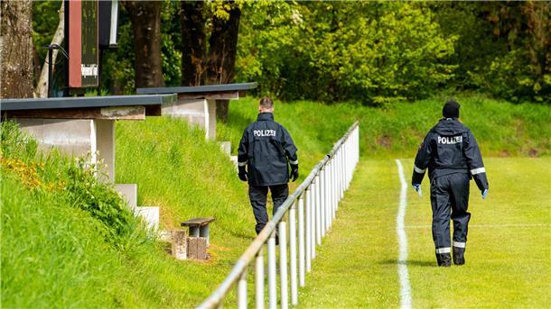 Suche nach Arian läuft weiter: Aufhören gibt es im Dorf Elm nicht Polizisten gehen auf der Suche nach Arian über einen Sportplatz. Doch auch dort wird der Sechsjährige nicht gefunden.