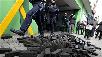 Polizisten gehen über einen Kohlehaufen, den Aktivisten verschiedener Umweltschutzgruppen vor der Grünen Parteizentrale in Nordrhein-Westfalen hingeworfen haben.