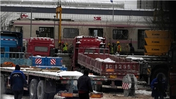 Polizisten in der Nähe des Ortes, wo sich der Zug-Unfall in Peking ereignete. Bei starkem Schneefall sind in Peking zwei U-Bahn-Züge zusammengestoßen.