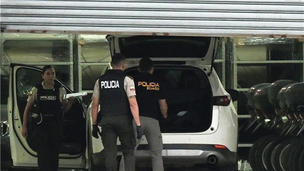 Bandenkämpfe in Ecuador: Leitender Staatsanwalt getötet Polizisten in Schutzwesten untersuchen das Auto des erschossenen Staatsanwalts César Suárez.