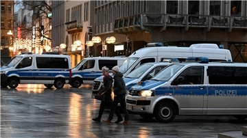 Polizisten kontrollieren am Eingang des Kölner Doms den Beginn der Frühmesse am Weihnachtstag.