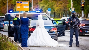 Polizisten kontrollieren Teilnehmer eines Hochzeitskorsos und ihre Fahrzeuge.