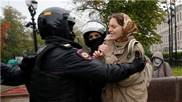 Polizisten nehmen bei Protesten in Moskau eine Frau fest.