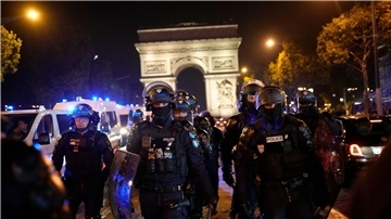 Polizisten patrouillieren vor dem Arc de Triomphe auf den Champs Élysées.