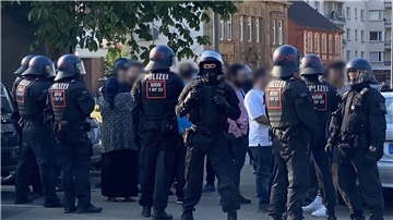 Polizisten schirmen nach der Massenschlägerei am Donnerstag eine Personengruppe ab. In der darauffolgenden Nacht versammelte sich erneut eine größere Gruppe von Menschen in der Innenstadt von Castrop-Rauxel.