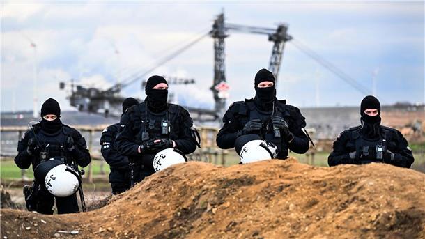 Polizisten sichern das Gelände beim Braunkohletagebau Garzweiler II.