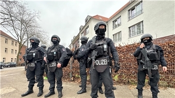 Polizisten stehen in der nähe des Tatorts in Billstedt, an dem zwei Männer durch einen Messerangriff tödlich verletzt worden sind.