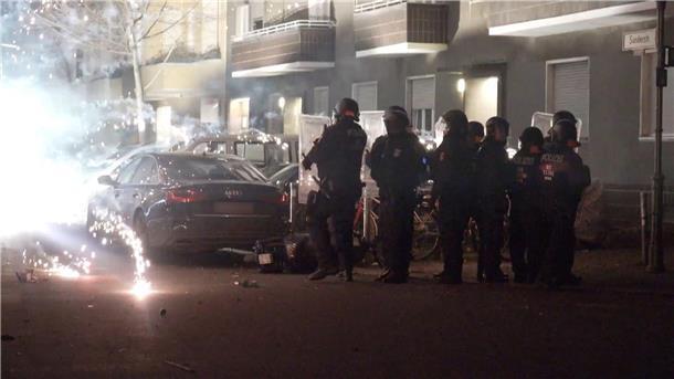 Wie Berlin erneute Krawalle an Silvester verhindern will Polizisten stehen in der Silvesternacht 2022 hinter explodierendem Feuerwerk in Berlin.