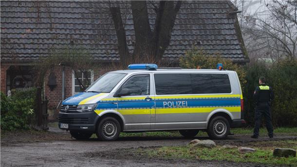 Polizisten stehen mit einem Polizeiwagen vor einem Haus, in dem zwei Tote gefunden wurden. Im Zuge des späteren Mordprozesses soll es Falschaussagen gegeben haben.