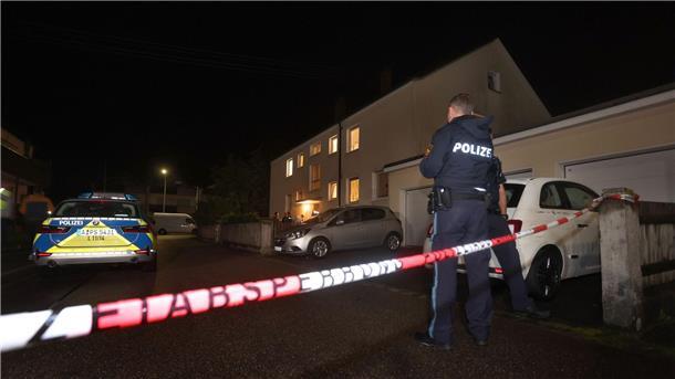 Tödliche Schüsse nach Streit unter Nachbarn Polizisten stehen vor einem Haus, in dem drei Menschen erschossen wurden.