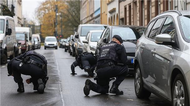 Kopfschuss in Krefeld - Ermittlungen laufen Polizisten suchen in der Nähe des Tatortes in Krefeld nach Spuren.