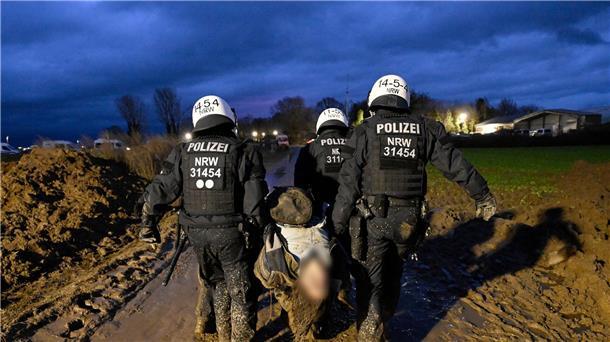 Lützerath bis auf zwei Aktivisten im Tunnel geräumt Polizisten tragen am Samstag einen verletzten Demonstranten davon.