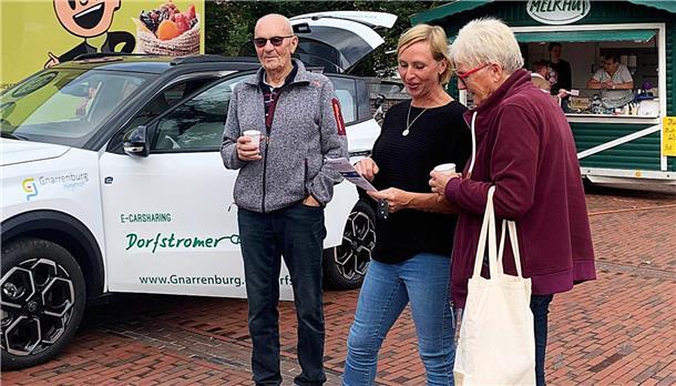 Präsentation des Dorfstromers auf dem Wochenmarkt in Gnarrenburg, Unser Foto zeigt interessierte Bürgerinnen und Bürger im Gespräch mit Gnarrenburgs Klimaschutzmanagerin Simone Kasnitz.