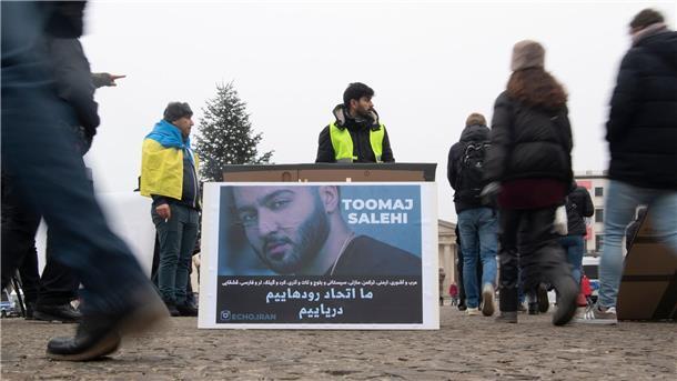 Zeitung: Iranischer Rapper Salehi zum Tode verurteilt Protestaktion gegen Irans Staatsführung auf dem Pariser Platz in Berlin. Auf dem Plakat ist der Rapper Salehi zu sehen.