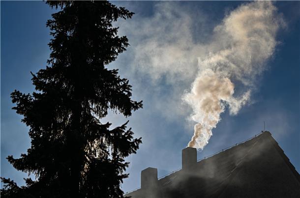 Qualm steigt aus dem Schornstein eines Einfamilienhauses. Bis 2045 soll damit vollständig Schluss sein, Öl und Gas zu verfeuern. Mitte 2026 sollen Wärmepläne klimaneutrale Alternativen aufzeigen.