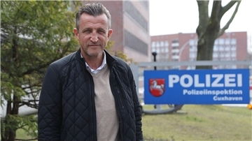 Rainer Brenner steht vor der Polizeiinspektion und blickt in Richtung der Kamera. 