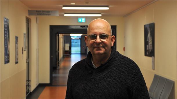 Mann mit Brille in einem schwarzen Pullover