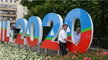 Raymond Kiesbye (links) und Oberbürgermeister Melf Grantz stellen Werbung für die Sail 2020 auf.