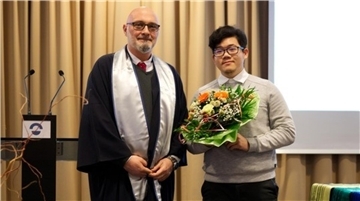 Rektor Prof. Dr. Dr. Alexis Papathanassis überreicht Siravit Puengyangyuen den DAAD-Preis für sein besonderes interkulturelles Engagement an der Hochschule.