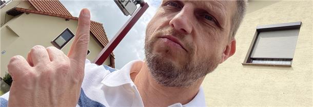 Mitfahrbänke auf dem Land: So sorgen sie für Mobilität Reporter Bert Albers sitzt auf einer Mitfahrbank in Tarmstedt. Das Schild über ihm zeigt an, dass er ins Nachbardorf Wilstedt mitgenommen werden möchte.