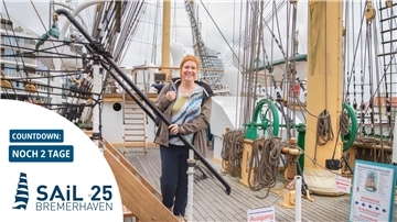 Frau geht an Bord eines Segelschiffes.