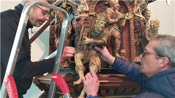 Restaurator Uwe Pleninger (links) und Kirchbauvereins-Vorsitzender Ibeling van Lessen justieren an der Kanzel die Figur des Königs David.
