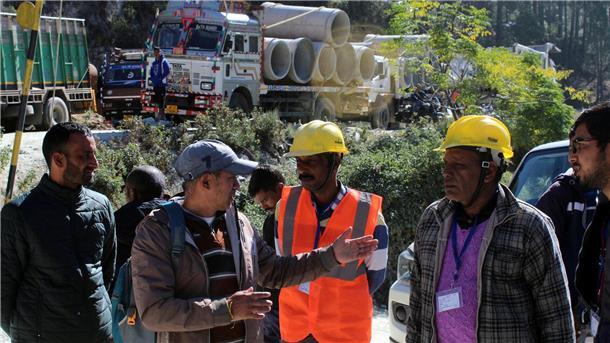 Retter beraten sich vor dem teilweise eingestürzten Straßentunnel im indischen Silkyara.