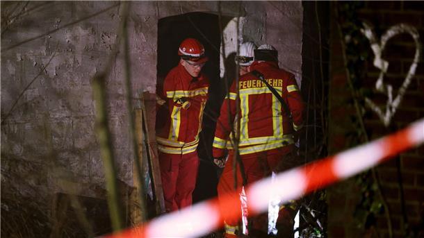 Abrissbagger in Lützerath - Widerstand bröckelt Rettungskräfte beraten vor eine Gebäude, in dem sich Personen in einem Tunnel verschanzt haben.