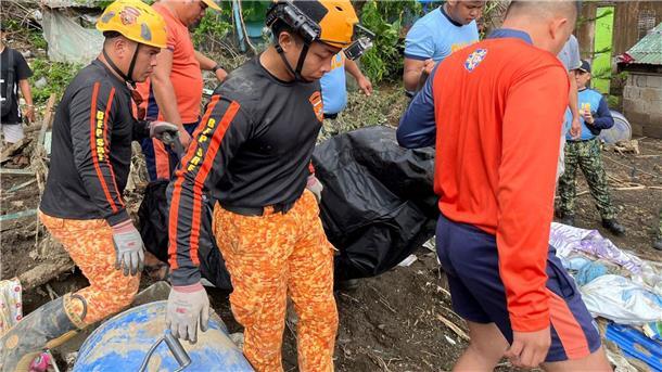 Tropensturm „Trami“ verwüstet Philippinen - Mehr als 80 Tote Rettungskräfte bergen eine Leiche nach einem Erdrutsch, der durch den Tropensturm Trami ausgelöst wurde