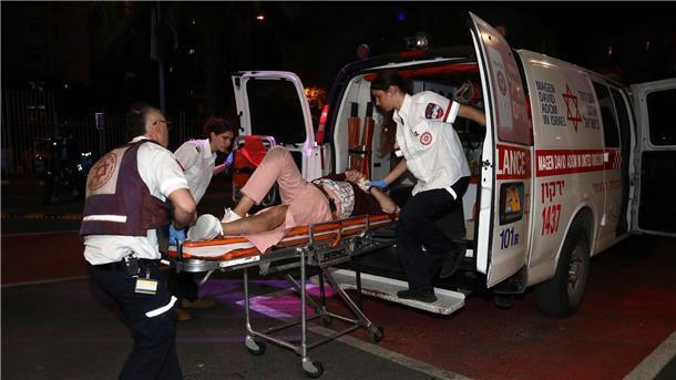 Rettungskräfte bringen eine verletzte Person in ein Krankenhaus in Tel Aviv.